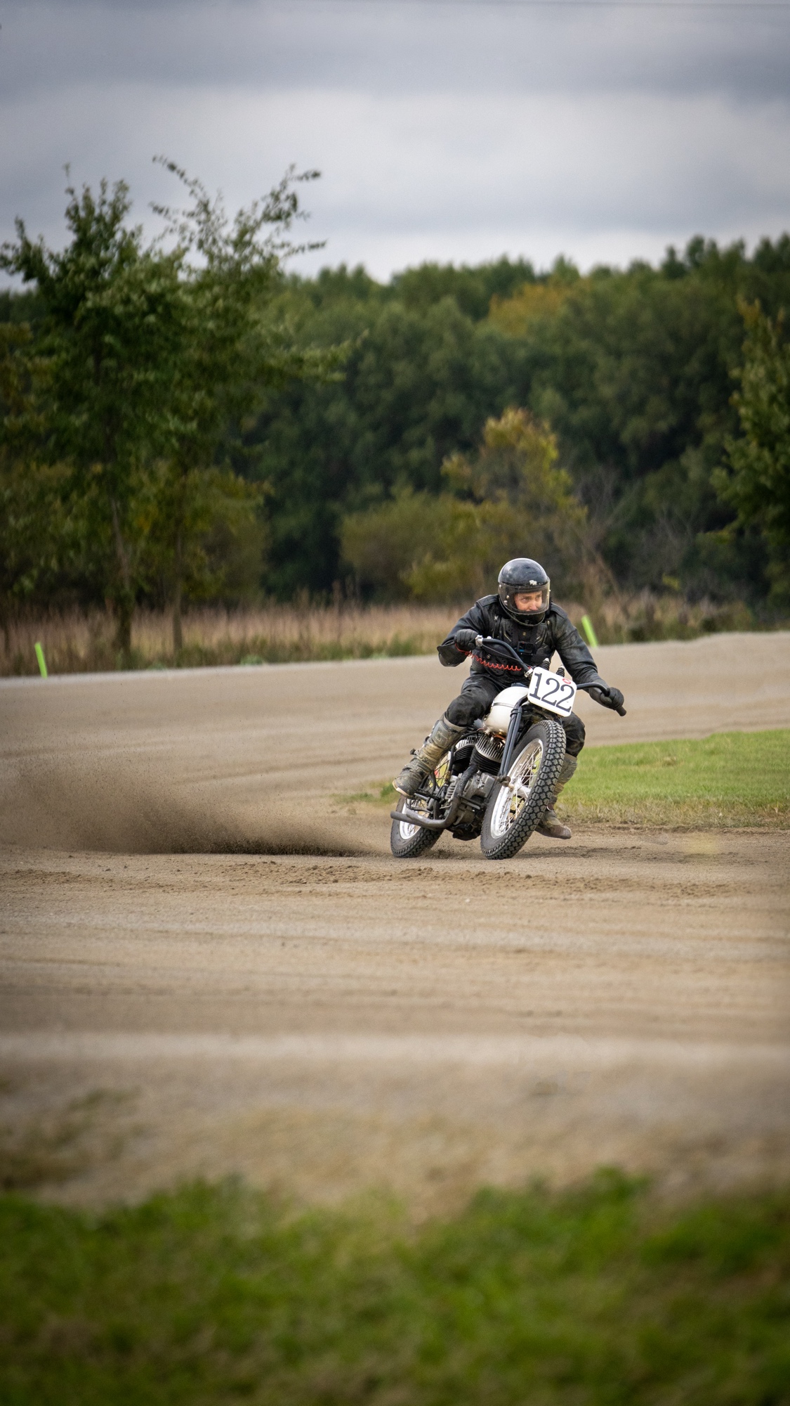 Flat-track racer #122 sliding into a corner.
