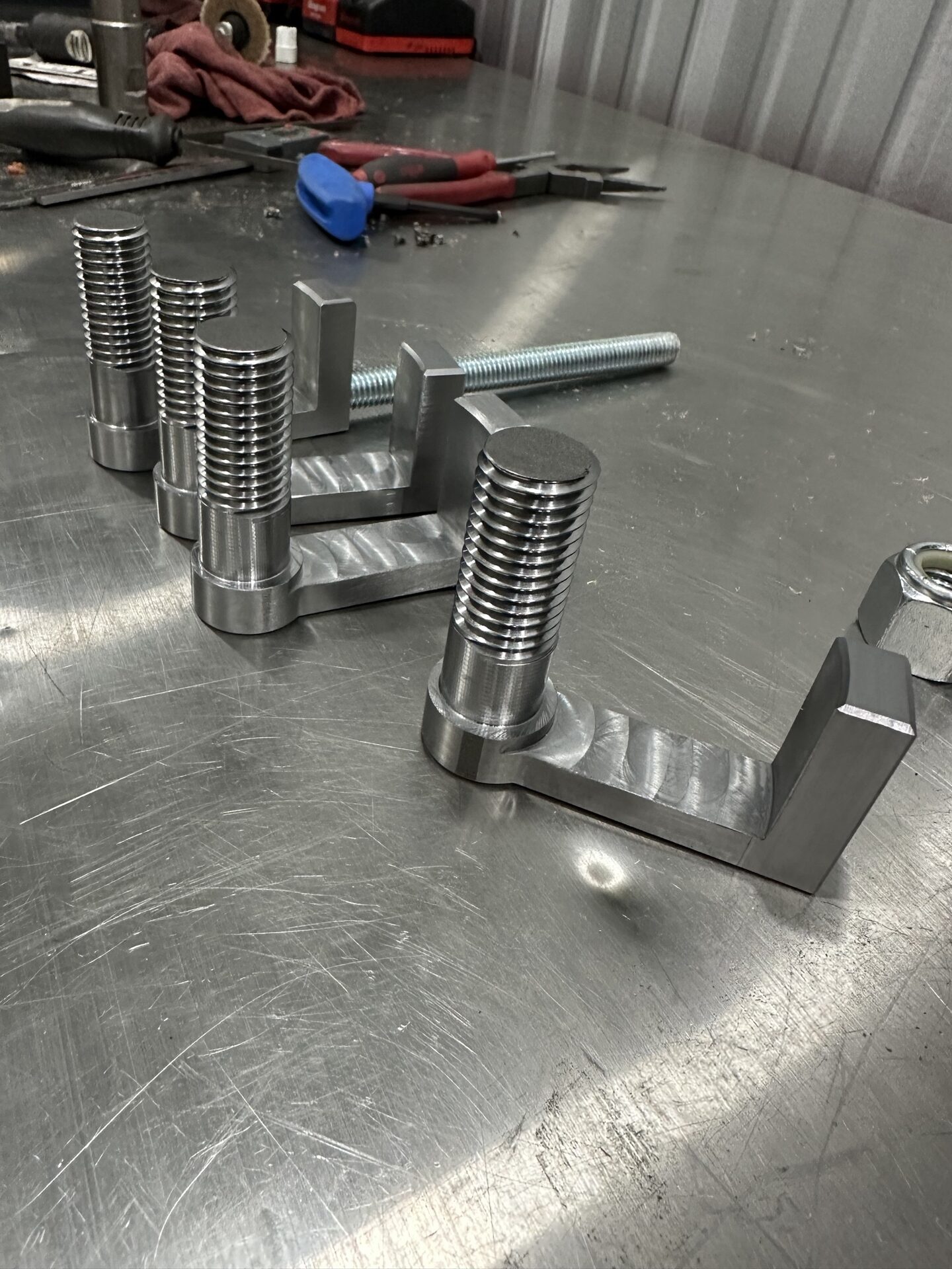 Machined rear pulley brackets staged in the shop.