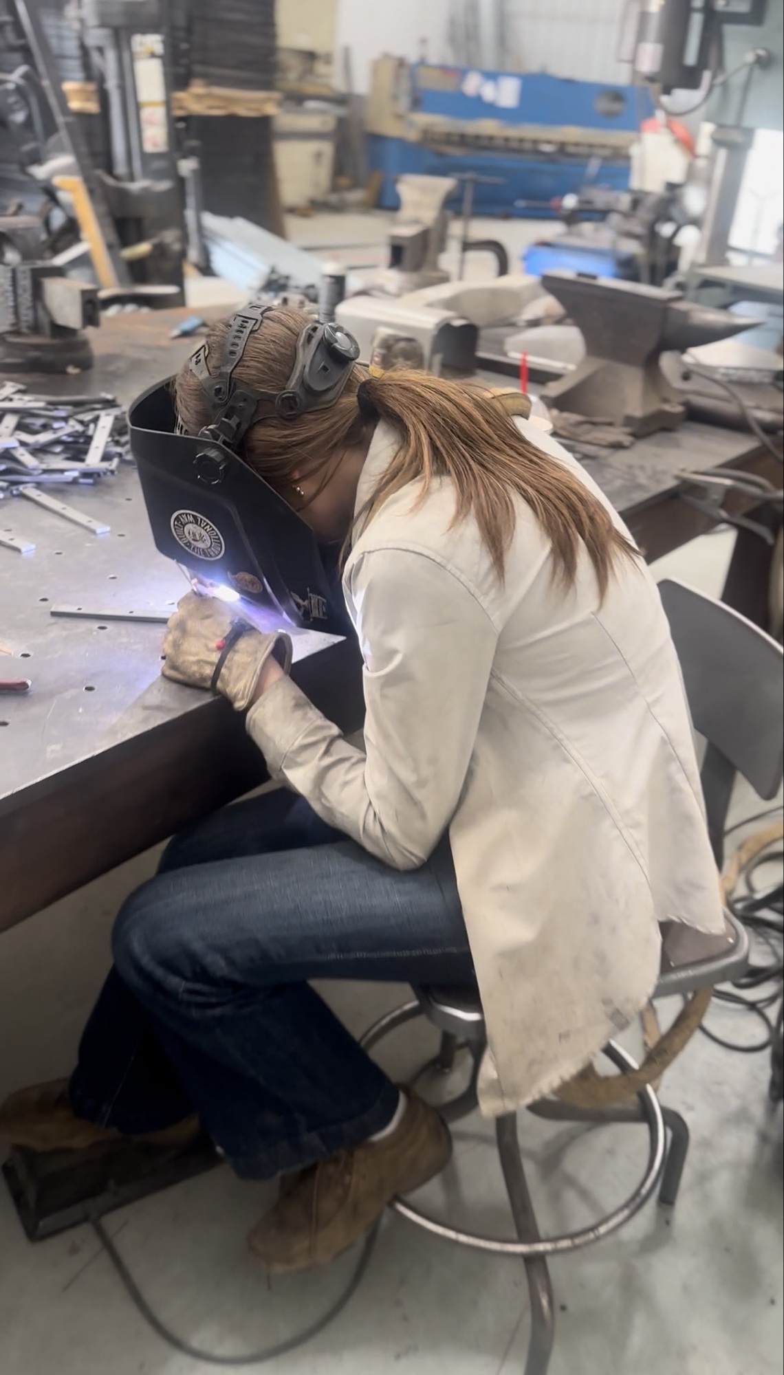 A welder building a Buffalo Tarp assembly at the bench.